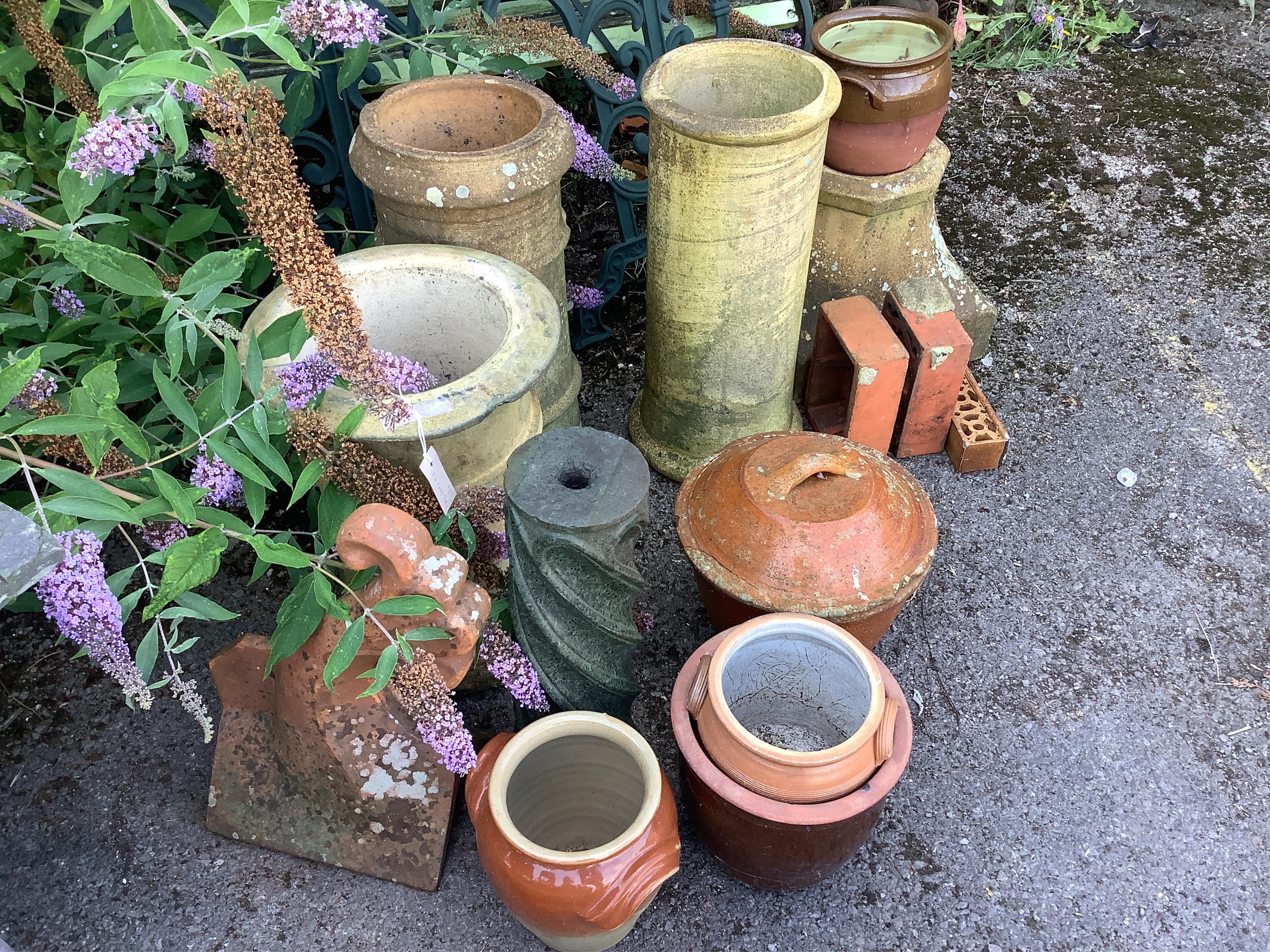 Fourteen assorted earthenware chimney pots, ridge tiles, lidded containers, etc., largest height 60cm. Condition - fair